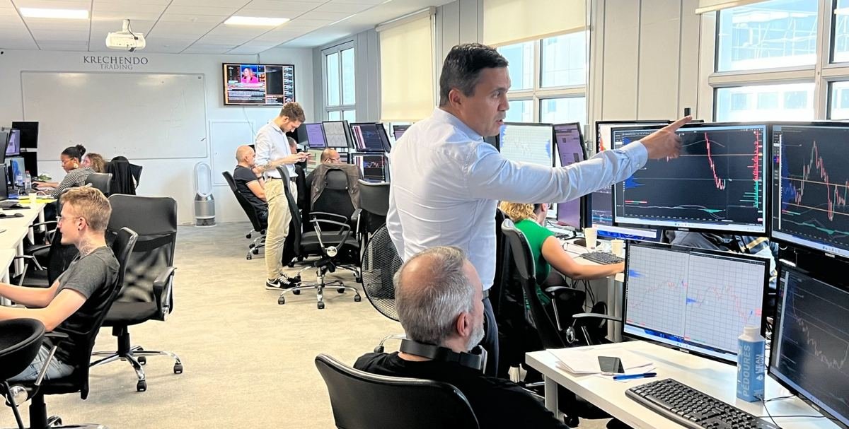 Salle de marché Krechendo en séance, un formateur commentant un graphique aux traders